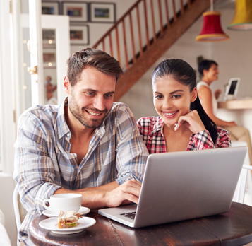 Smiling Couple Looking at Laptop